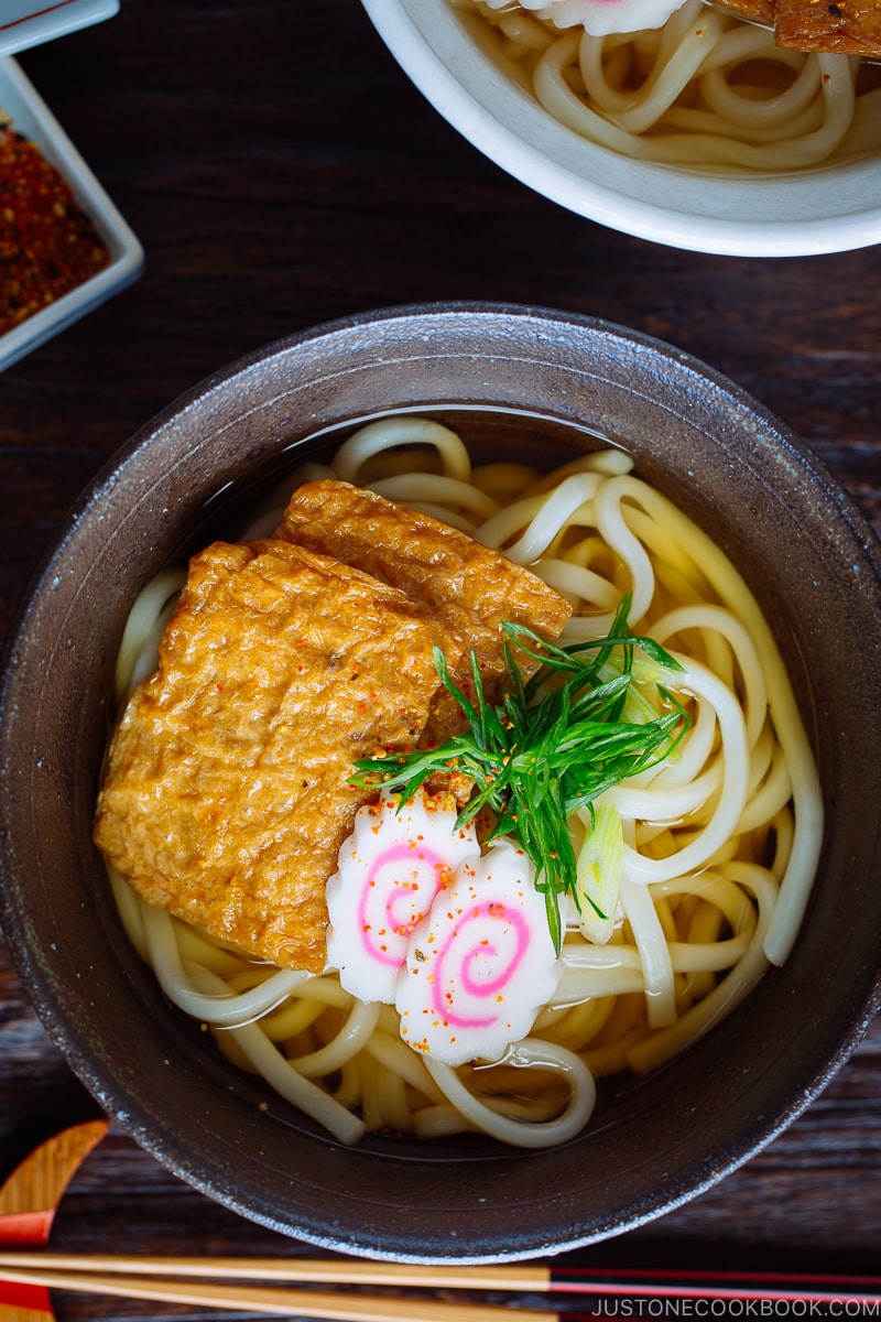 A dark bowl containing Kitsune Udon Noodle Soup.