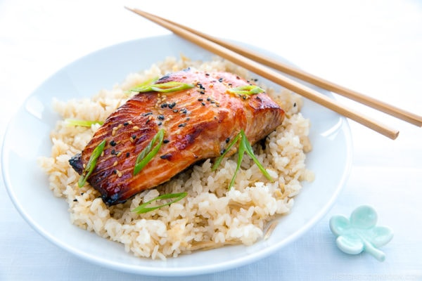 A white bowl containing miso salmon over ginger rice.