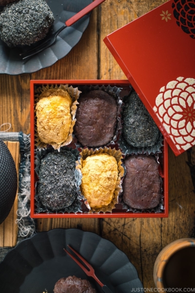 A lacquer box containing Ohagi (Botamochi) and some of them are served on a black plate.