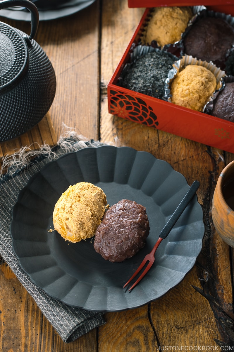 A lacquer box containing Ohagi (Botamochi) and some of them are served on a black plate.