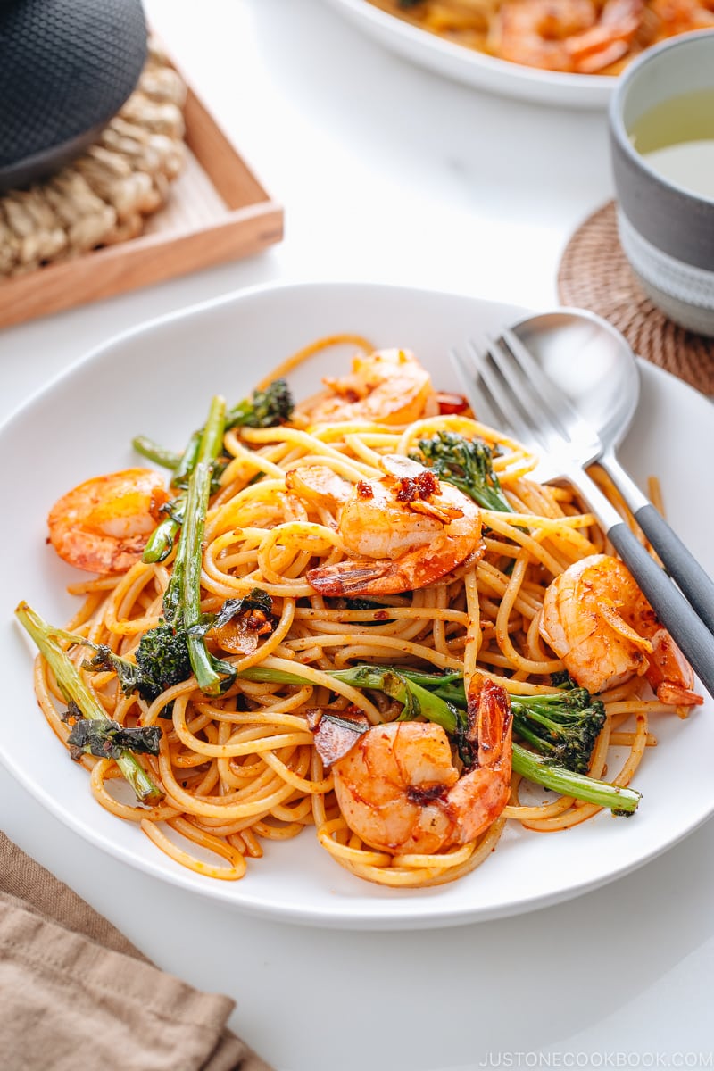 A white plate containing Japanese Pasta with Shrimp and Broccolini.