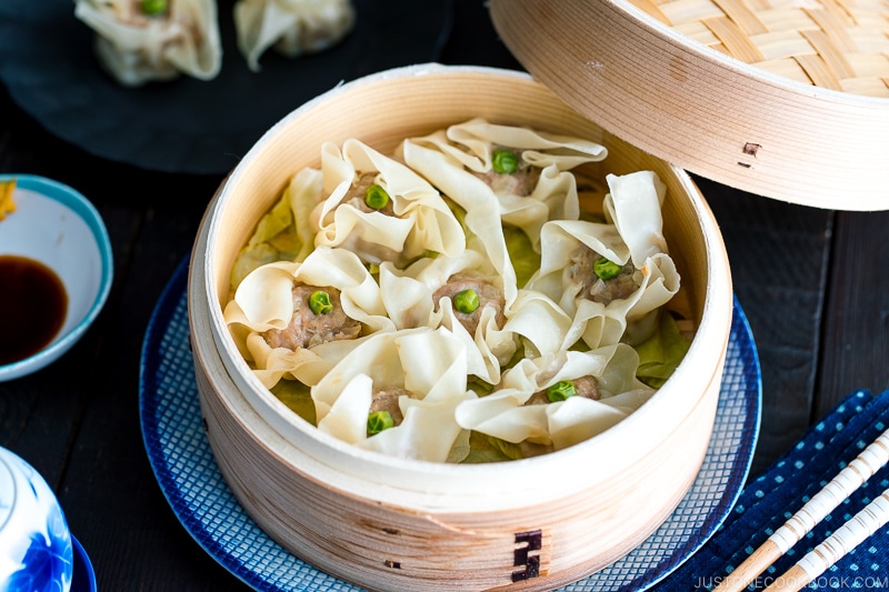 A bamboo steamed basket containing pork shumai (steamed pork dumplings).