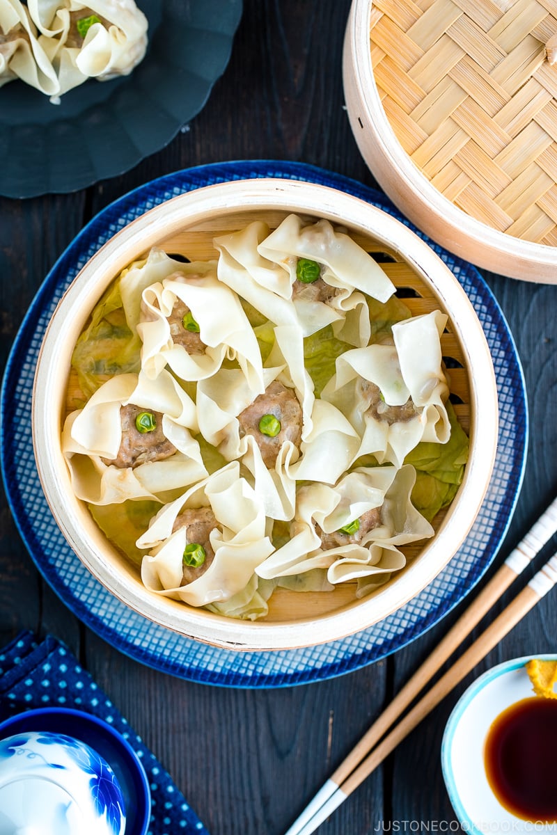 A bamboo steamed basket containing pork shumai (steamed pork dumplings).