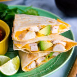 A green plate containing teriyaki chicken quesadilla.