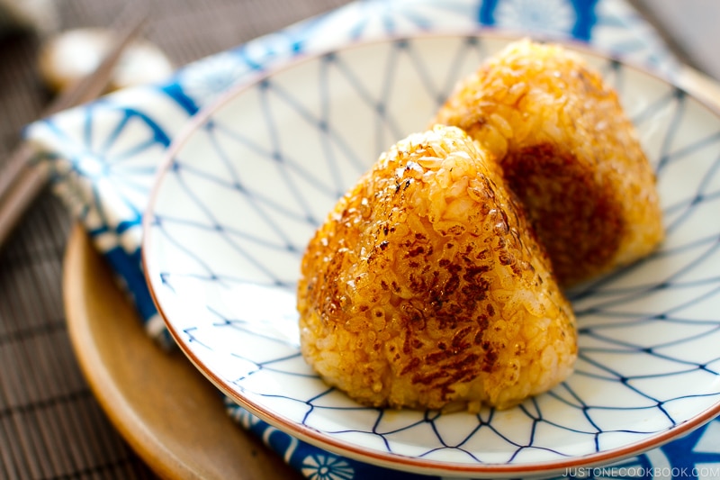 A Japanese blue and white plate containing Yaki Onigiri - Japanese Grilled Rice Balls).