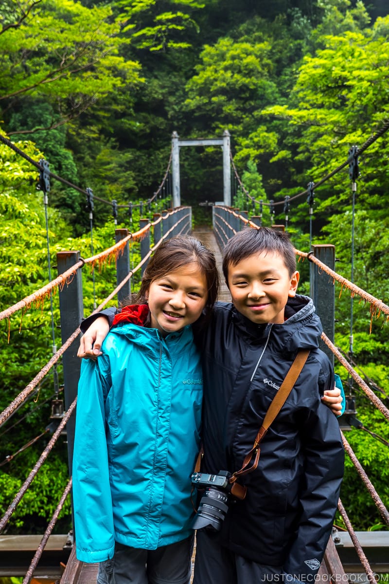 boy and girl on suspension bridge at Shiratani Unsui Gorge - Yakushima Travel Guide | www.justonecookbook.com