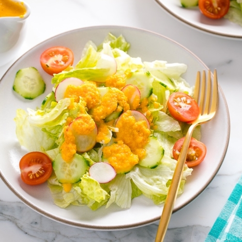 Carrot ginger dressing drizzled on the refreshing iceberg lettuce and cucumber slices.