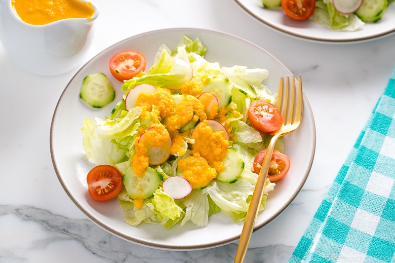 Carrot ginger dressing drizzled on the refreshing iceberg lettuce and cucumber slices.