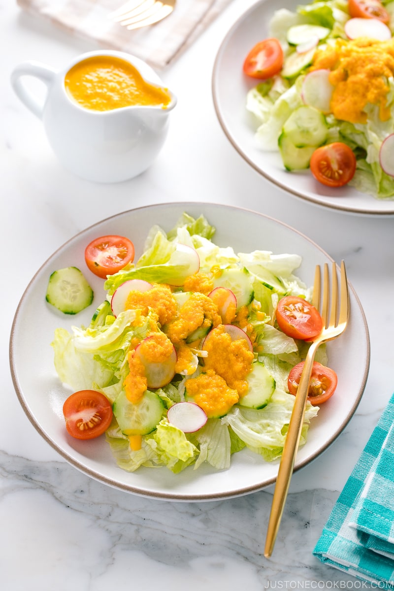 Carrot ginger dressing drizzled on the refreshing iceberg lettuce and cucumber slices.