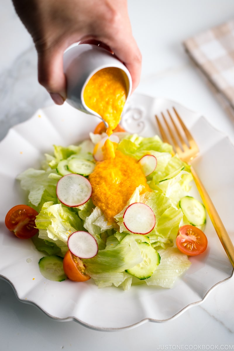 Carrot ginger dressing drizzled on the refreshing iceberg lettuce and cucumber slices.