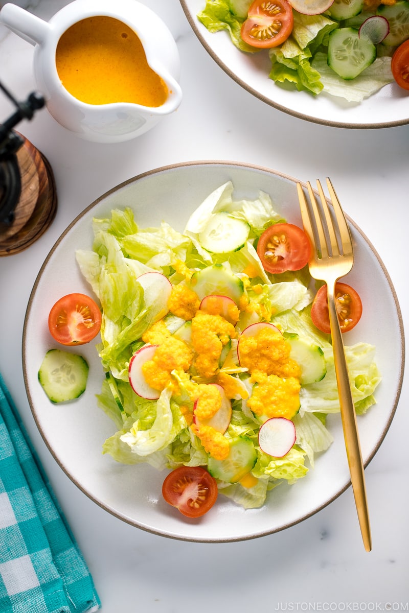 Une vinaigrette carotte-gingembre arrosée de laitue iceberg rafraîchissante et de tranches de concombre.