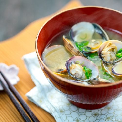 A red bowl containing Clam Miso Soup.