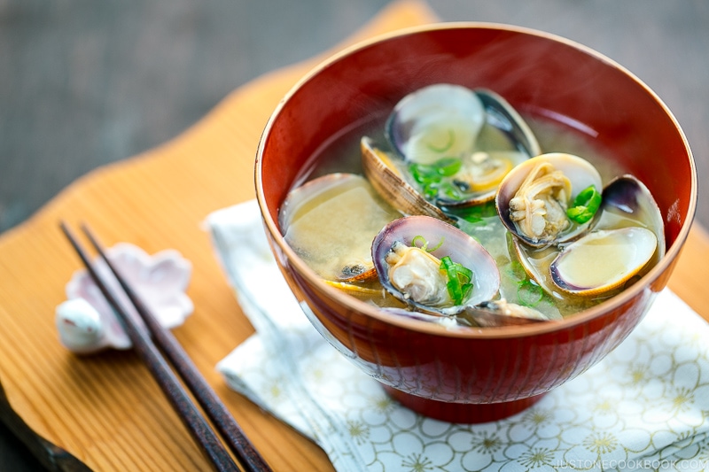 A red bowl containing Clam Miso Soup.