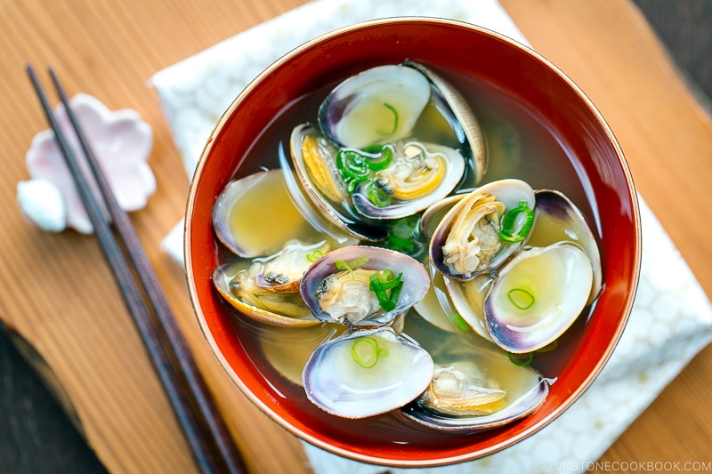 A red bowl containing Clam Miso Soup.