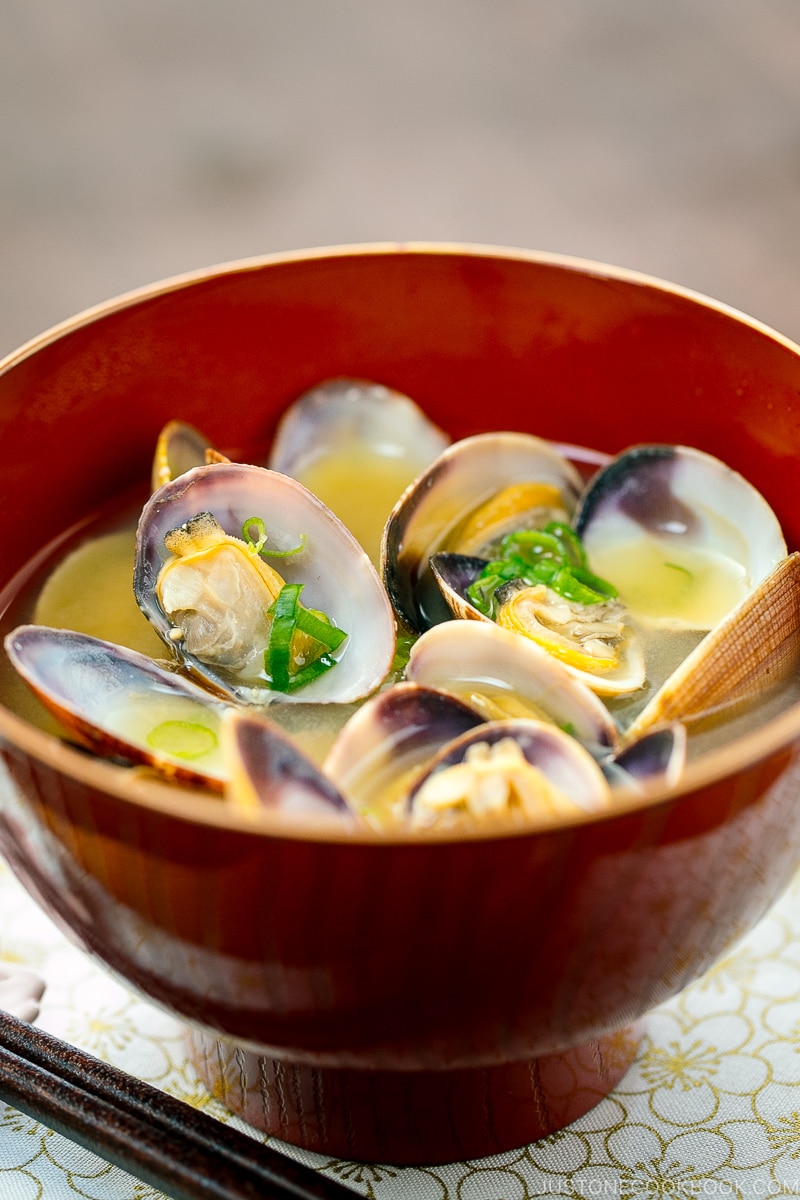 A red bowl containing Clam Miso Soup.