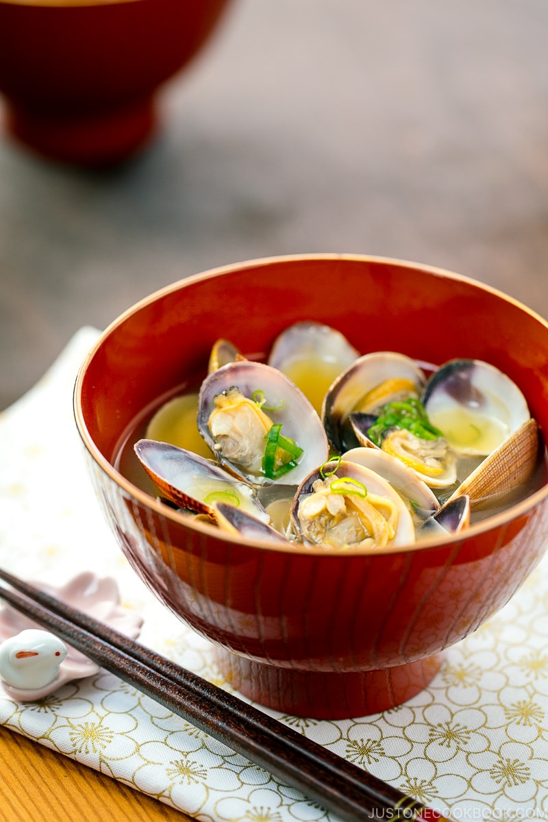 A red bowl containing Clam Miso Soup.