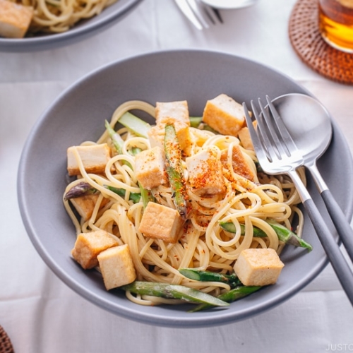 A grey bowl containing Creamy Miso Pasta with Tofu and Asparagus.