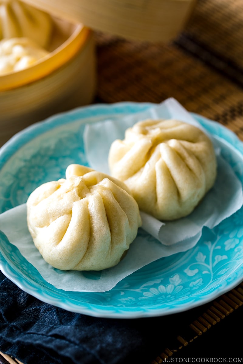 A blue dish containing Steamed Pork Buns (Nikuman).