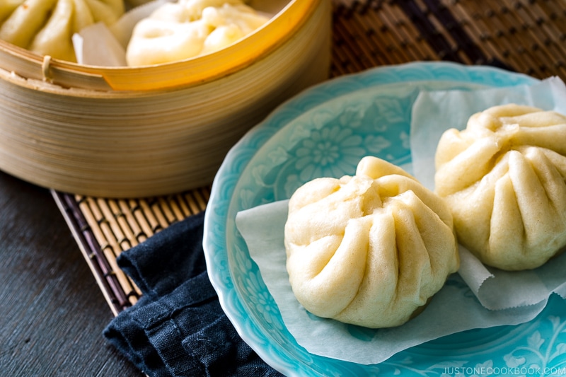 A blue dish containing Steamed Pork Buns (Nikuman).