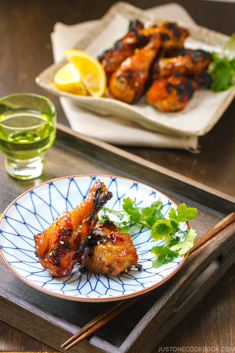 A blue and white plate containing Sweet and Spicy BBQ Chicken Wings.