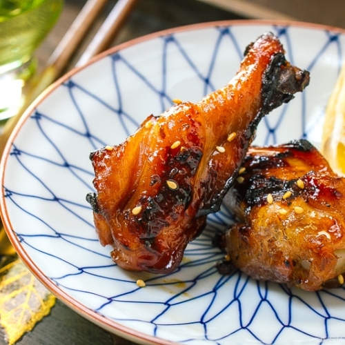 A blue and white plate containing Sweet and Spicy BBQ Chicken Wings.