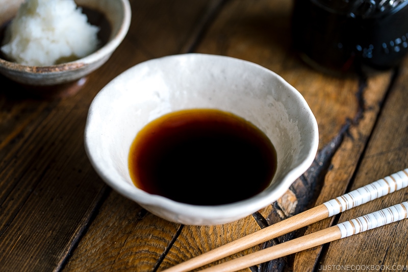 A white bowl containing Tempura Dipping Sauce (Tentsuyu) served with grated daikon.