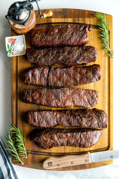 steaks reverse seared to medium rare, medium, and medium well on Traeger on top of wood cutting board