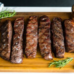 steaks reverse seared to medium rare, medium, and medium well on Traeger on top of wood cutting board