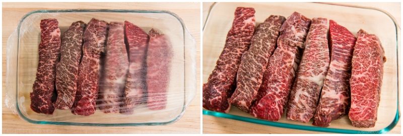 uncooked steak in glass tray covered with plastic wrap