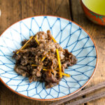 A white and blue Japanese dish containing Simmered Beef with Ginger (Shigureni).