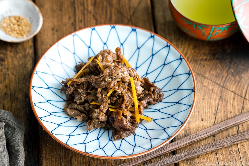 A white and blue Japanese dish containing Simmered Beef with Ginger (Shigureni).