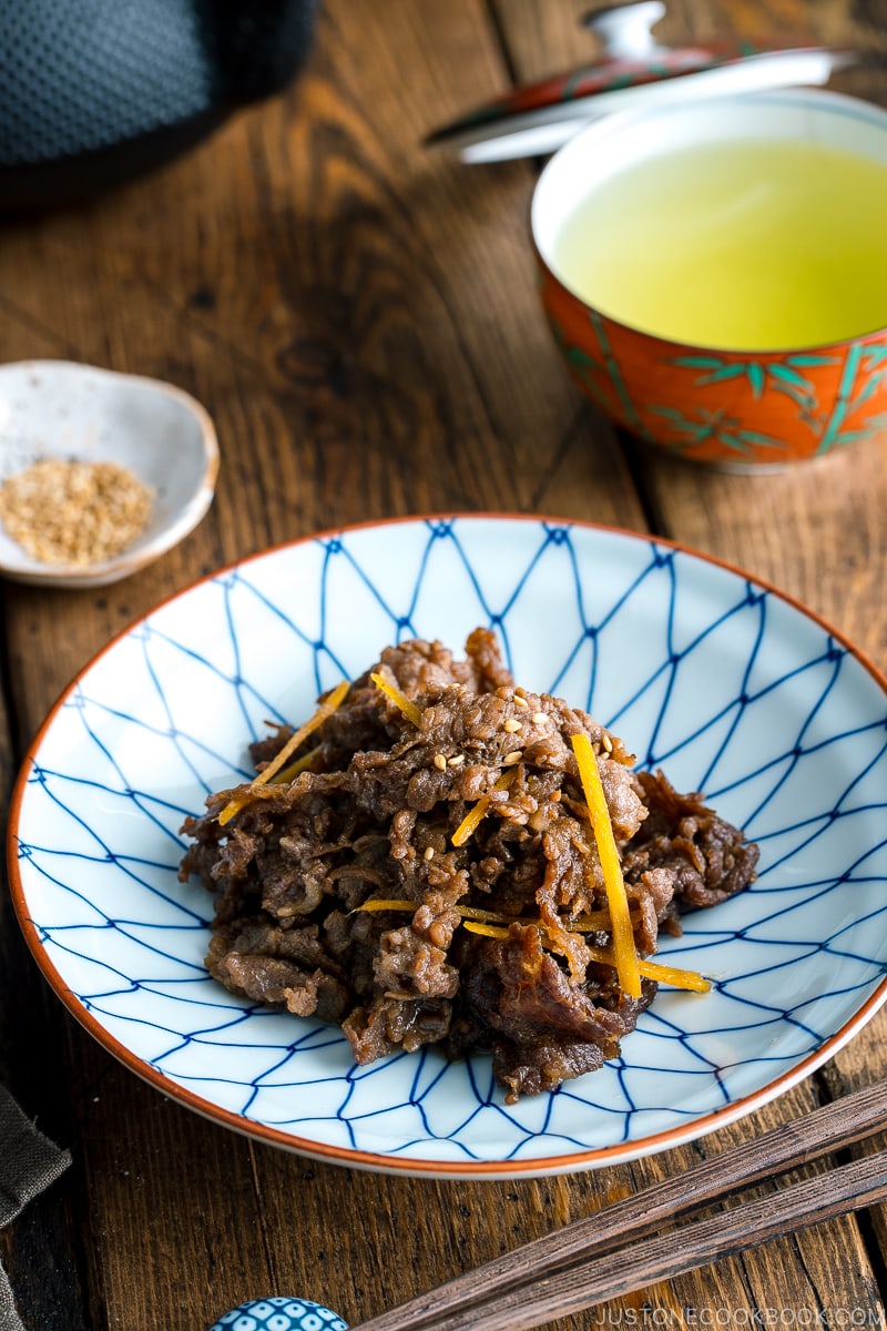 A white and blue Japanese dish containing Simmered Beef with Ginger (Shigureni).