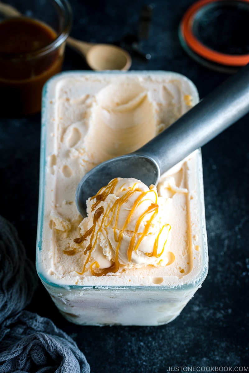 A glass bowl containing Soy Sauce Caramel Ice Cream topped with a drizzle of extra caramel.