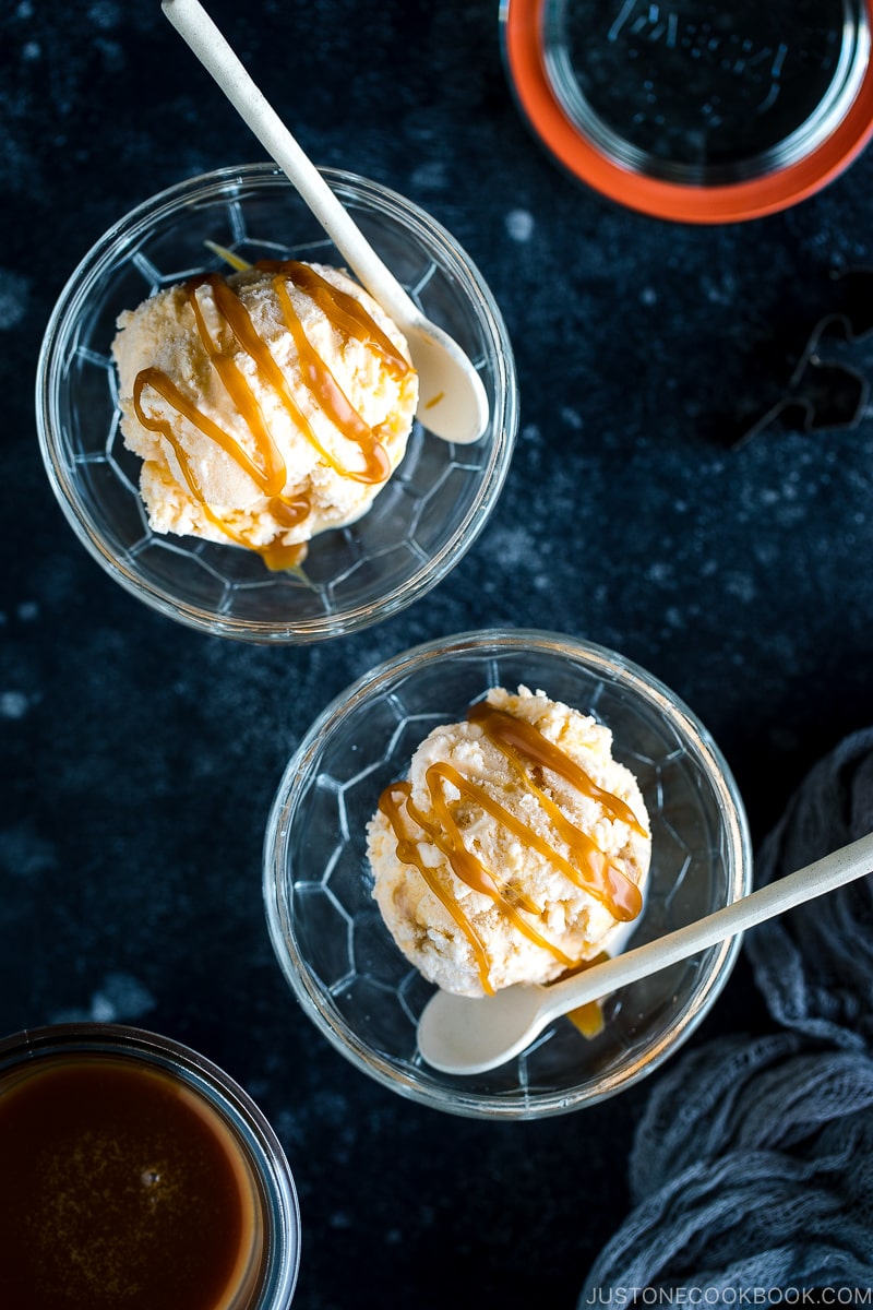 A glass bowl containing Soy Sauce Caramel Ice Cream topped with a drizzle of extra caramel.