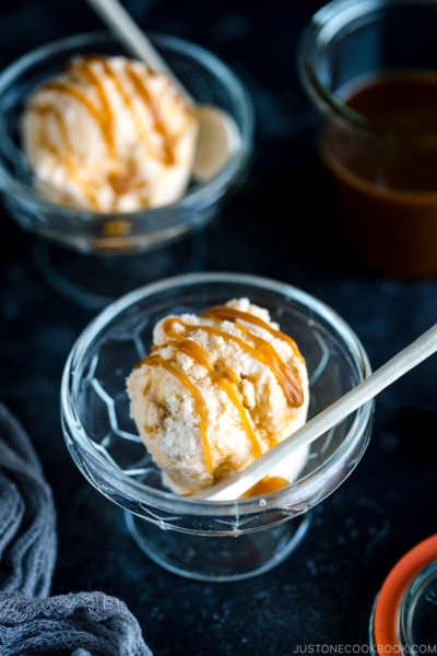 A glass bowl containing Soy Sauce Caramel Ice Cream topped with a drizzle of extra caramel.