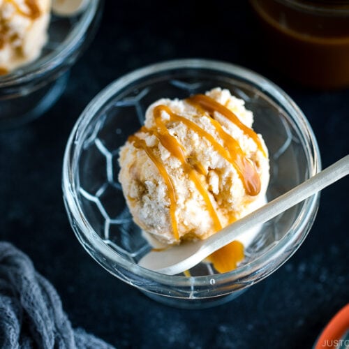 A glass bowl containing Soy Sauce Caramel Ice Cream topped with a drizzle of extra caramel.