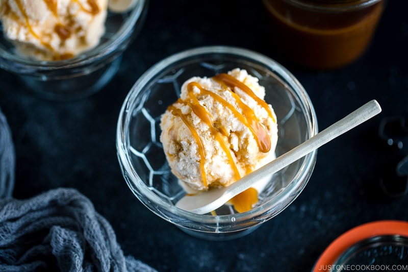 A glass bowl containing Soy Sauce Caramel Ice Cream topped with a drizzle of extra caramel.