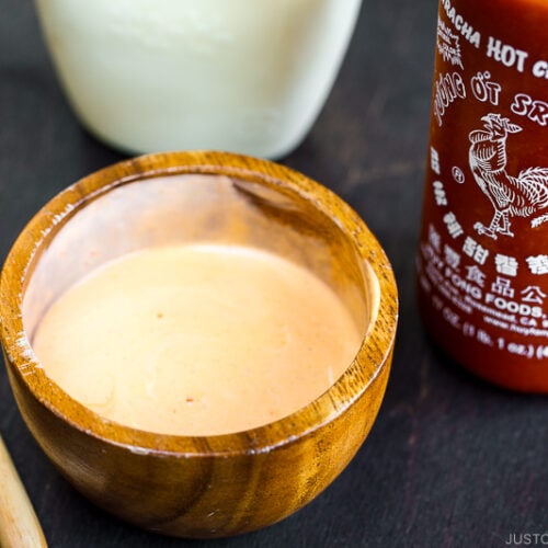 A wooden bowl containing spicy mayo.