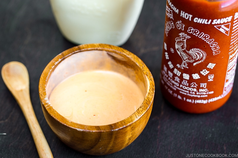 A wooden bowl containing spicy mayo.