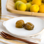 A white plate containing ume plum compote.