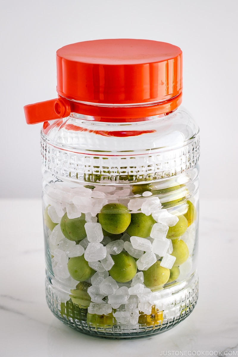 A glass container containing ume plum and rock candy.