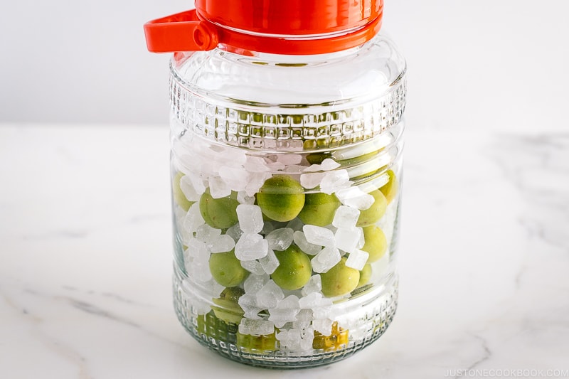 A glass container containing ume plum and rock candy.
