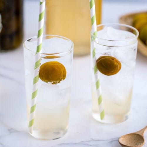 Tall glasses containing ume syrup cider and ume compote.