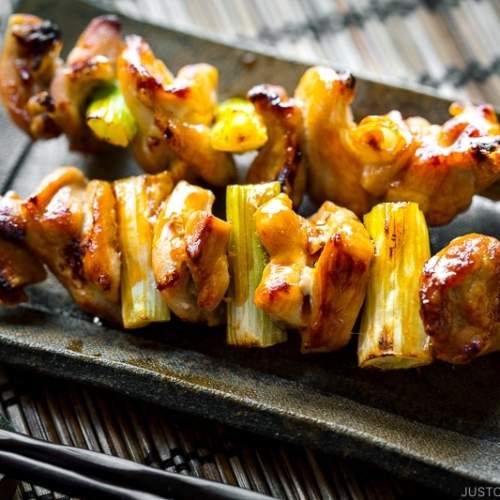 A ceramic plate containing Yakitori.