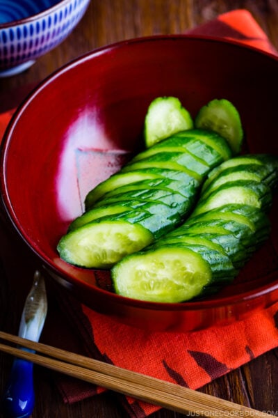 A red lacquer bowl containing Pickled Cucumber.