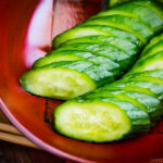 A red lacquer bowl containing Pickled Cucumber.