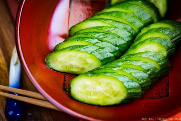 A red lacquer bowl containing Pickled Cucumber.