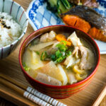 Tonjiru (Pork and Vegetable Soup) served with grilled salmon, steamed rice, and vegetable side dishes.