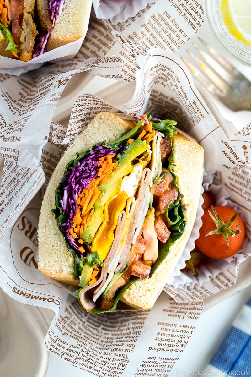 Colorful thick Japanese sandwich, Wanpaku Sandiwch (Sando), shows the filling and piles up on the table.