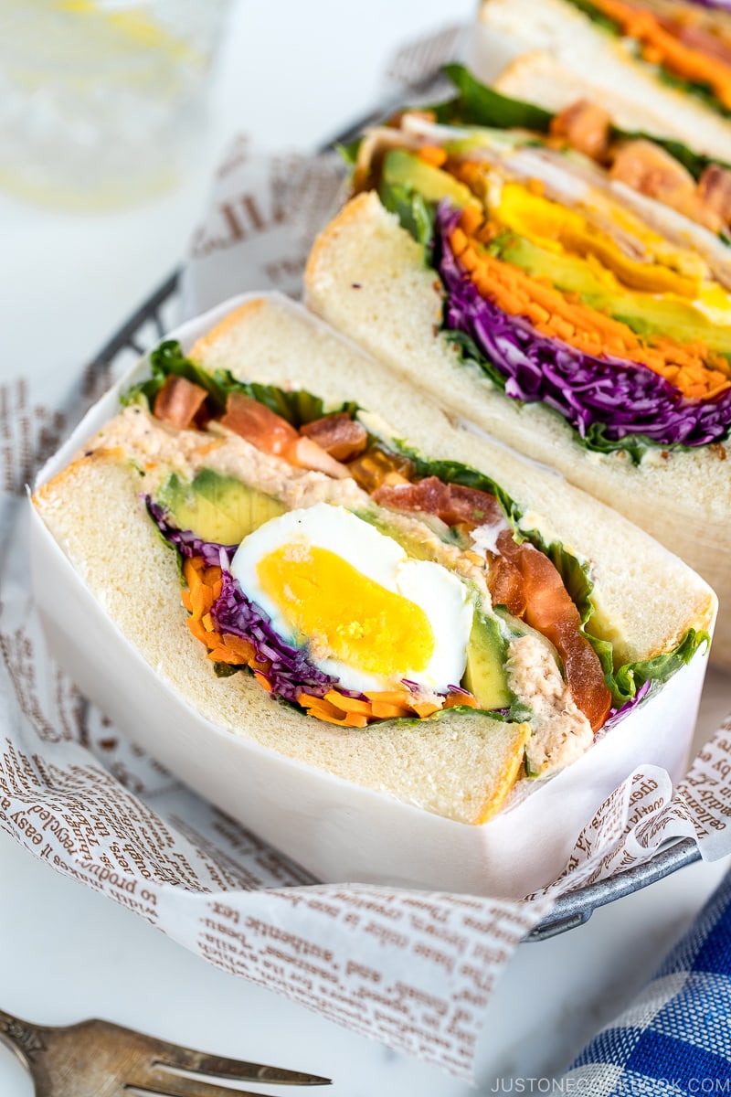 Colorful thick Japanese sandwich, Wanpaku Sandiwch (Sando), shows the filling and piles up on the table.